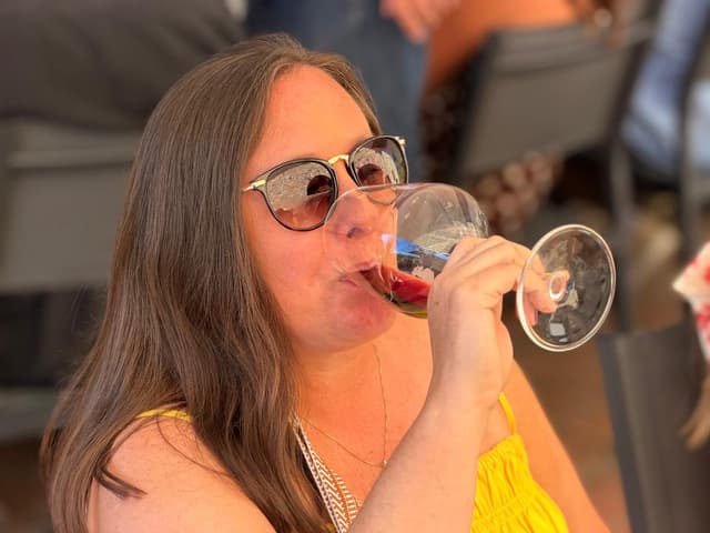 Close-up of a guest tasting red wine in the golden light of the afternoon