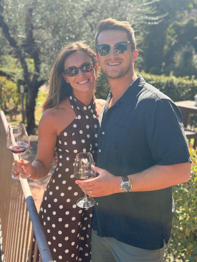Couple with glasses of red wine on the terrace among the olive trees