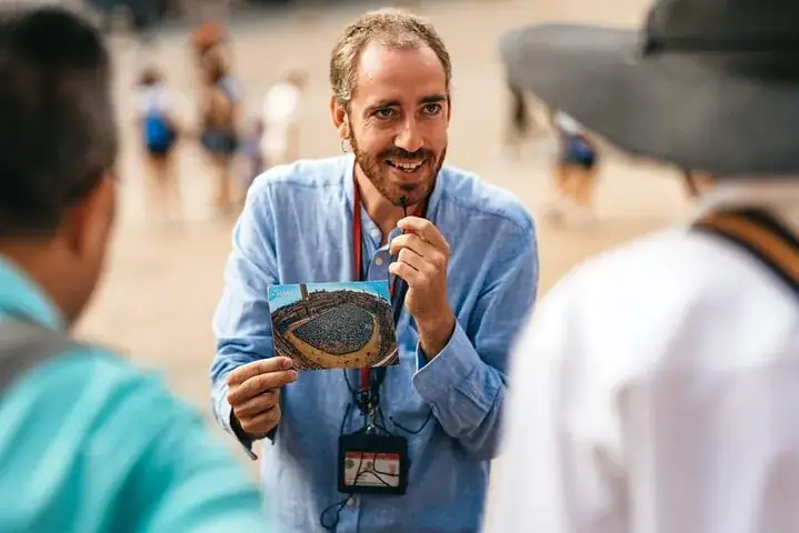 A Prestige Rent guide showing guests a postcard of Piazza del Campo